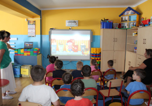 Przedszkolaki oglądają bajkę na tablicy multimedialnej