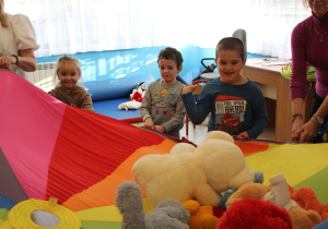 Zabawa z chustą animacyjną - na zdjęciu Ania, Kuba i Krzysiu