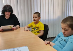 Krzyś i Mikołaj słuchają bajkę czytaną przez panią Ewę