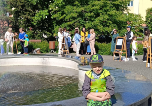 Wiosenne malowanie - na zdjęciu Kacper przy fontannie, w tle inni uczestnicy konkursu