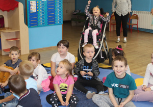 Przedszkolaki Miłosz, Lena, Maja, Olek, Denisa, Adaś, Marika, Hana i Karol siedzą na dywanie