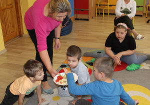 Smakowanie owoców i warzyw - na zdjęciu Ksawery, Krzysiu i Boguś z panią Agnieszką, w tle Natalia