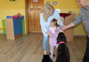 Ania oswaja się z pieskiem w obecności p. Gosi i p. Andrzeja