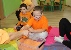 Dzień pomarańczowy - na zdjęciu Szymon poszukuje skarbów w pomarańczowym ryżu