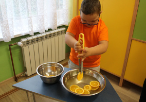 Dzień pomarańczowy - na zdjęciu Szymon łowi plastry pomarańczy