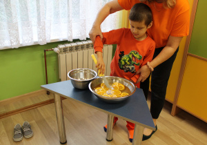 Dzień pomarańczowy - na zdjęciu Ksawery łowi plastry pomarańczy