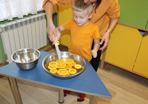 Dzień pomarańczowy - na zdjęciu Filip łowi plastry pomarańczy