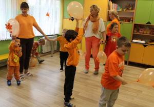 Dzień pomarańczowy - na zdjęciu przedszkolaki wraz z paniami podczas tańca z balonami