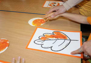 Dzień pomarańczowy - na zdjęciu dziecko w trakcie kolorowania liścia
