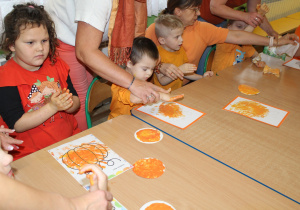 Dzień pomarańczowy - na zdjęciu przedszkolaki podczas malowania