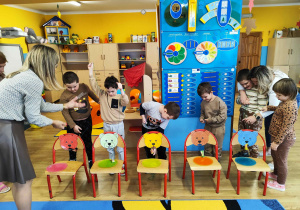 Chłopcy przeciągają cukierki na sznureczkach, przez pyszczek misia.