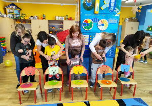 Dzieci przeciągają cukierki na sznureczkach, przez pyszczek misia.