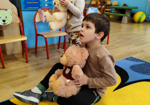 Mikołaj z Antosiem przytulają misie.