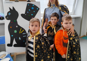 Chłopcy z p. Ulą na tle swojej pracy plastycznej.