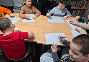 Chłopcy wykonują pracę plastyczną.