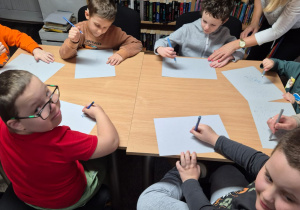 Chłopcy wykonują pracę plastyczną.