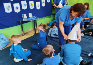 Dzień niebieski - p. Asia z p. Ulą zakładają dzieciom czapki