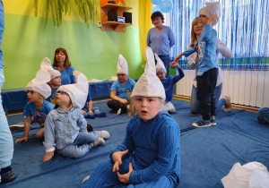 Dzień niebieski - przedszkolaki w smerfnych czapkach siedzą na niebieskim dywanie.