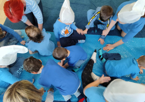 Dzień niebieski - przedszkolaki dotykają folii bąbelkowej.