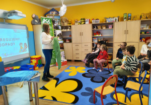 Pani z PGK prezentuje zielony worek na szkło