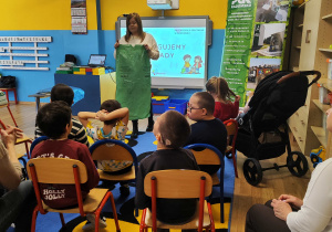 Pani z PGK prezentuje zielony worek na szkło