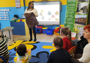 Pani z PGK prezentuje brązowy worek na bio odpady