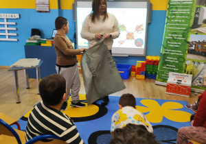 Pani z PGK z Mikołajem prezentują worek na odpady zielone