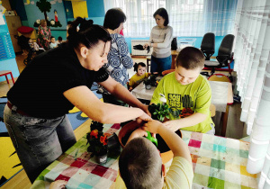 Dzieci przesadzają kwiatki