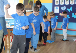 Przedszkolne obchody Dni Autyzmu - na zdjęciu przedszkolaki na torze z dysków fakturowych