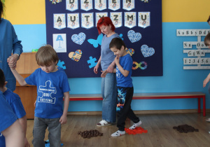 Przedszkolne obchody Dni Autyzmu - na zdjęciu przedszkolaki na torze z dysków fakturowych