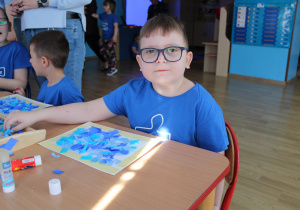 Przedszkolne obchody Dni Autyzmu - na zdjęciu Yaroslav ze swoją pracą plastyczną