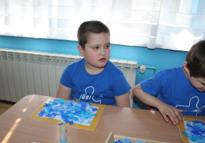 Przedszkolne obchody Dni Autyzmu - na zdjęciu Krzysiu podczas wykonywania pracy plastycznej